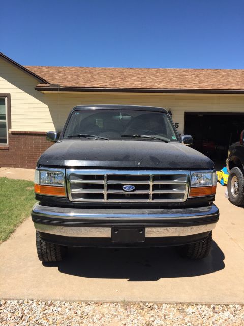 1994 Ford Bronco - Front view of a dark-colored Ford F-Series truck parked in a driveway.