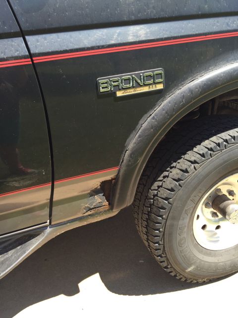 1994 Ford Bronco - This 1994 Ford Bronco Eddie Bauer shows rust damage on its lower side panel, a common issue for vehicles of this era.