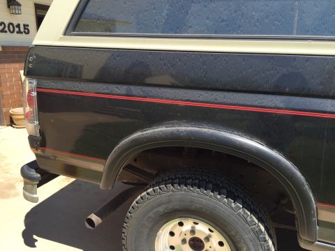 1994 Ford Bronco - The rear section of a black Ford Bronco, a two-tone paint scheme and red accent stripes.
