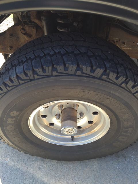 1994 Ford Bronco - A close-up view of a vehicle's tire and wheel assembly, with visible suspension parts.