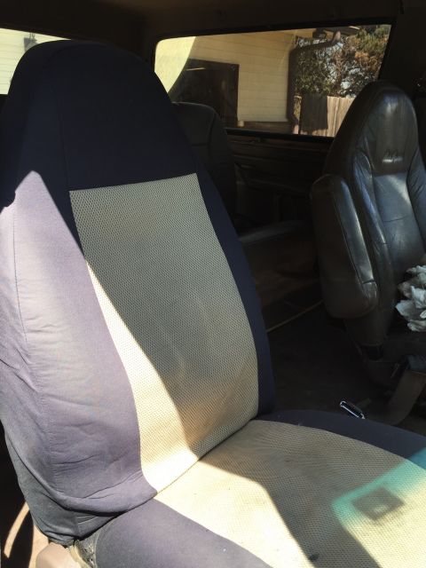 1994 Ford Bronco - Interior view of a vehicle, focusing on the driver's seat with a fabric cover.