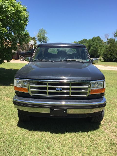 1994 Ford Bronco - Front view of a dark blue 1994 Ford Bronco parked on grass.
