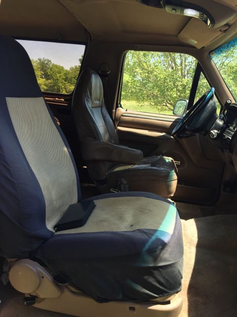 1994 Ford Bronco - The interior of a Ford Bronco is shown, with a view of the front seats and the driver's side controls.