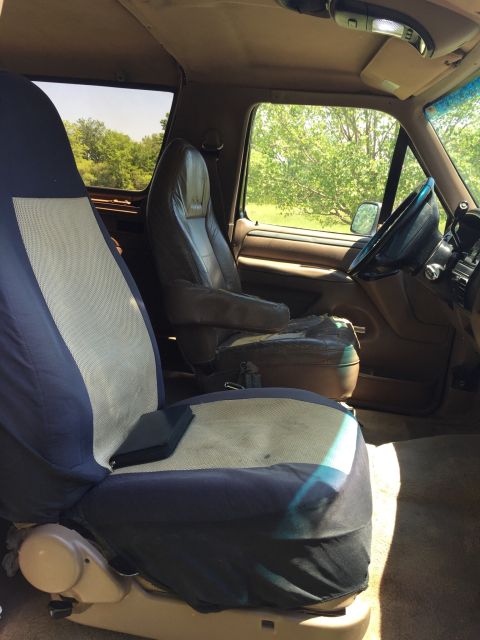 1994 Ford Bronco - The interior of a 1992 Ford Bronco shows worn seats and seat covers.