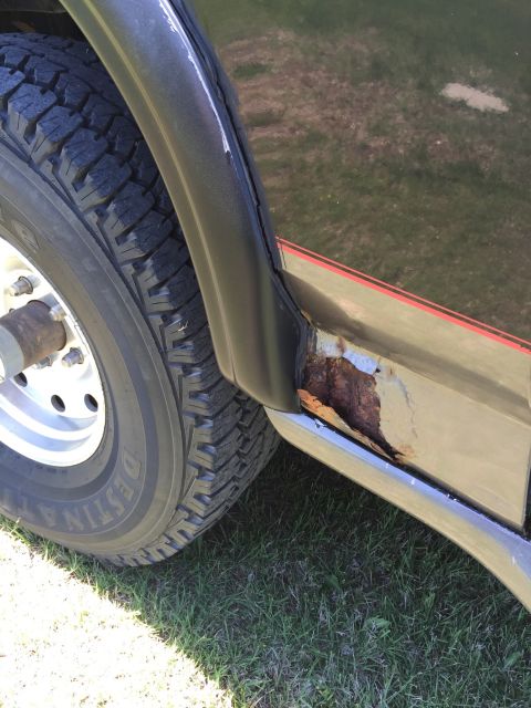 1994 Ford Bronco - A close-up view of the side of a 1994 Ford Bronco reveals significant rust damage on the rocker panel.