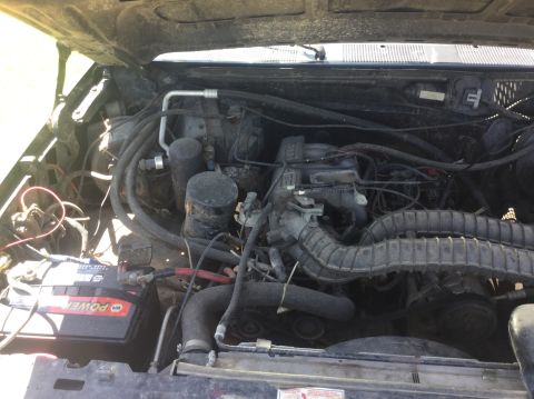 1994 Ford Bronco - The engine bay of a vehicle is shown with various components and wiring.