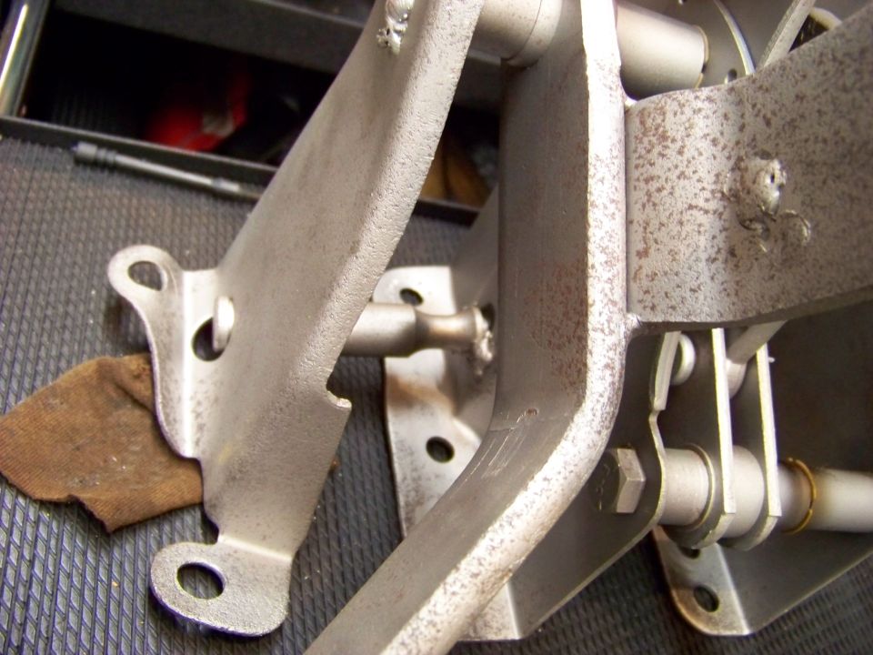 Close-up of a metal pedal assembly with pivot points and mounting brackets