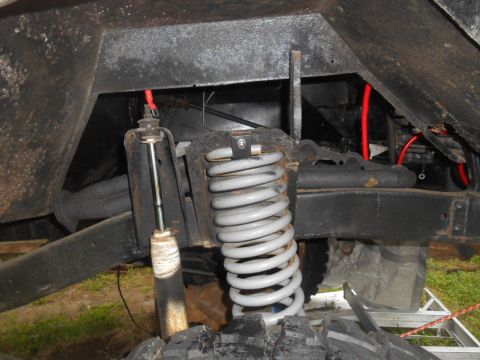 1972 Ford Bronco - The image shows the suspension system of a vehicle, focusing on the coil spring and shock absorber.