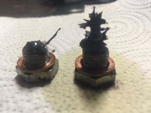 1982 Ford Bronco - Oil drain plugs show significant metal debris, indicating potential engine wear.