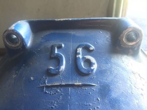 1982 Ford Bronco - A close-up view of a blue metal component with embossed numbers '56' and a horizontal line.
