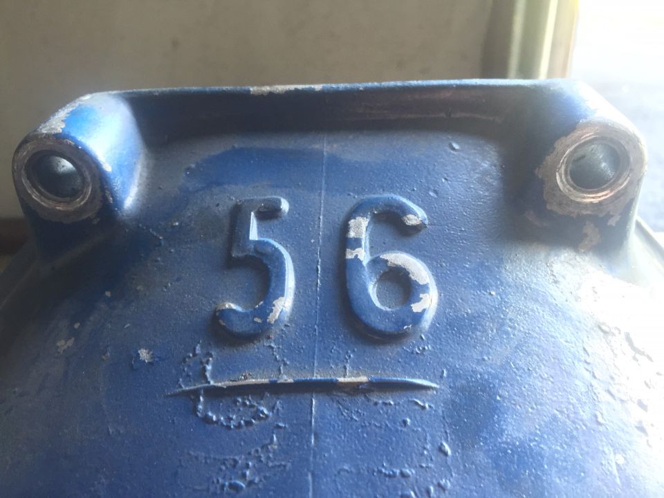 Blue metal part with embossed numbers '56' and a horizontal line