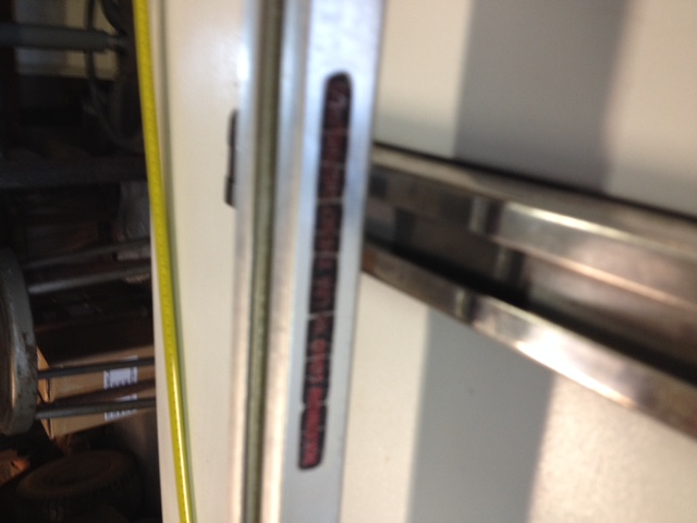 Metal gauge with red markings and a yellow tape measure
