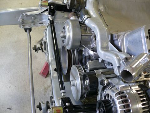 Close-up of engine pulleys, alternator, and metal framework