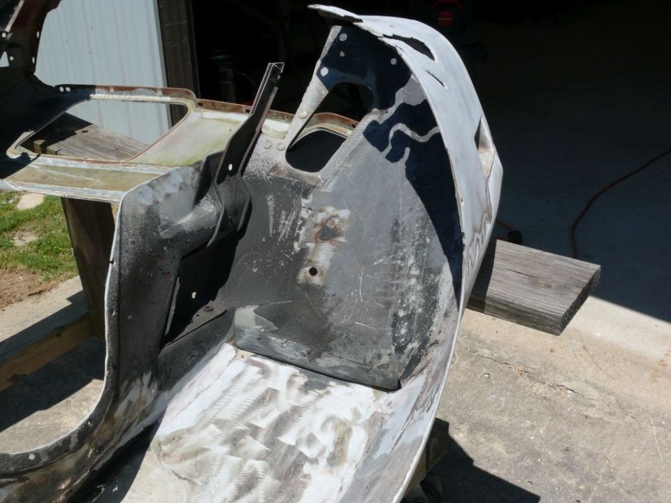 car body panel on sawhorses, looks like it's being prepped for repair