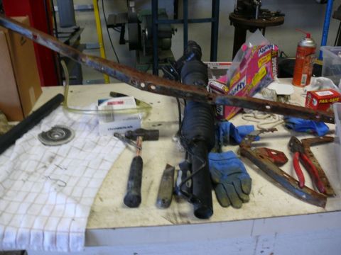Tie rod and steering rack components on a workbench with tools