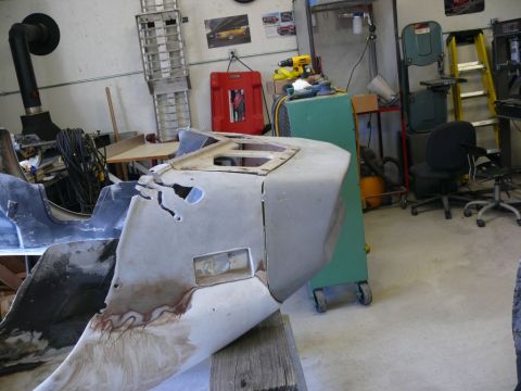 car body parts on a workbench in a workshop with tools and equipment in the background