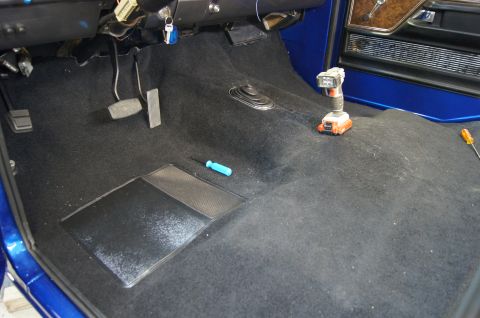 1979 Ford Bronco - The interior floor of a vehicle is shown with new black carpet and tools, suggesting ongoing work.