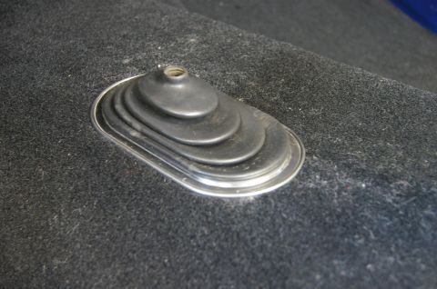1979 Ford Bronco - A close-up view of a shifter boot on a carpeted floor.