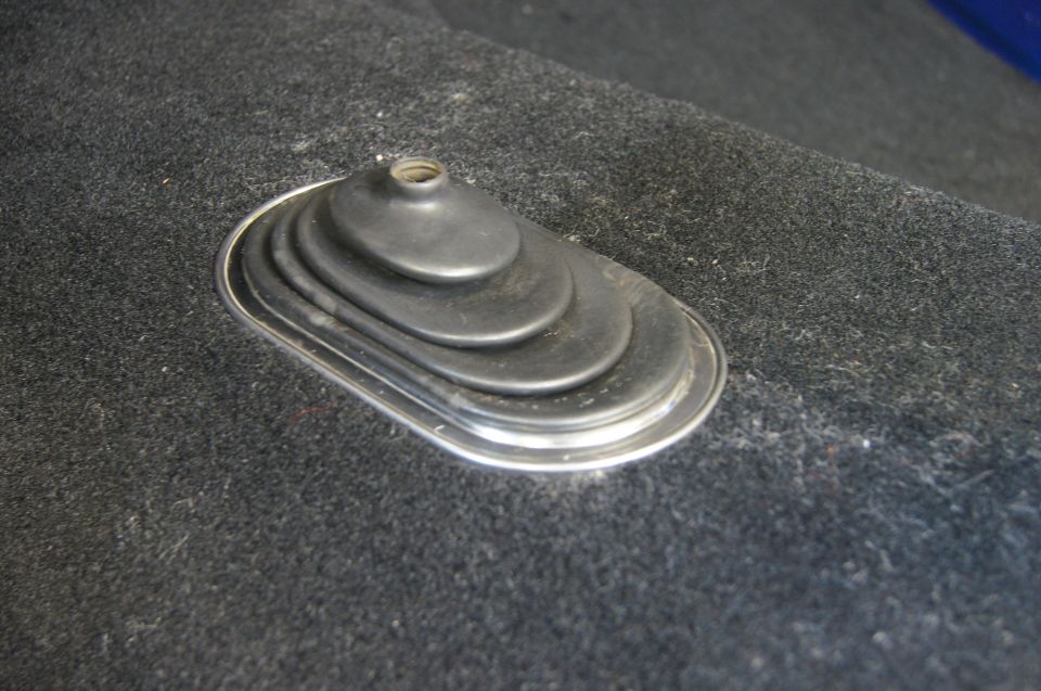 Carpeted floor with a chrome-trimmed rubber shifter boot