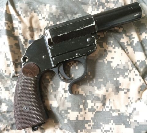 1987 Ford Bronco - A black flare gun is shown against a camouflage pattern. The registry claims it is a 1987 Ford Bronco, which is incorrect.