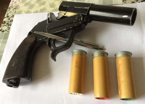 1987 Ford Bronco - A black flare gun is shown with three cartridges next to it.