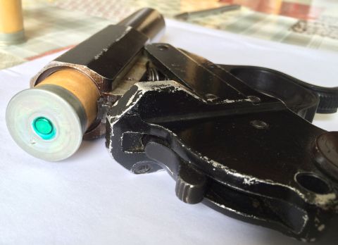 1987 Ford Bronco - A flare gun and cartridge are shown in detail, resting on a surface with a checkered tablecloth in the background.