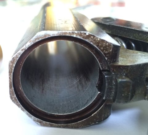 1987 Ford Bronco - A close-up view of a metal cylinder part, showing internal wear and a hexagonal outer shape.