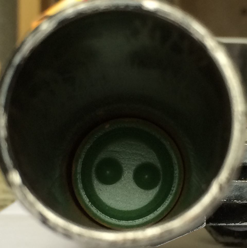 Interior of an exhaust pipe showing a green fitting with two circular openings