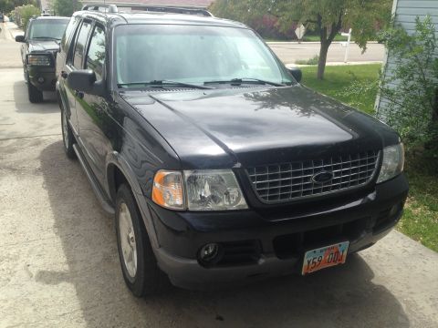 2004 Ford Explorer - Front view of a black 2004 Ford Explorer parked on a driveway with another vehicle behind it.
