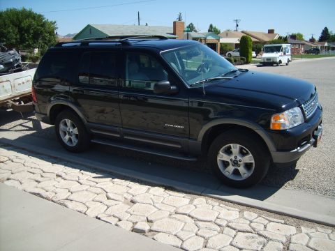 2004 Ford Explorer - A black Ford Explorer is parked on a residential street, attached to a trailer.
