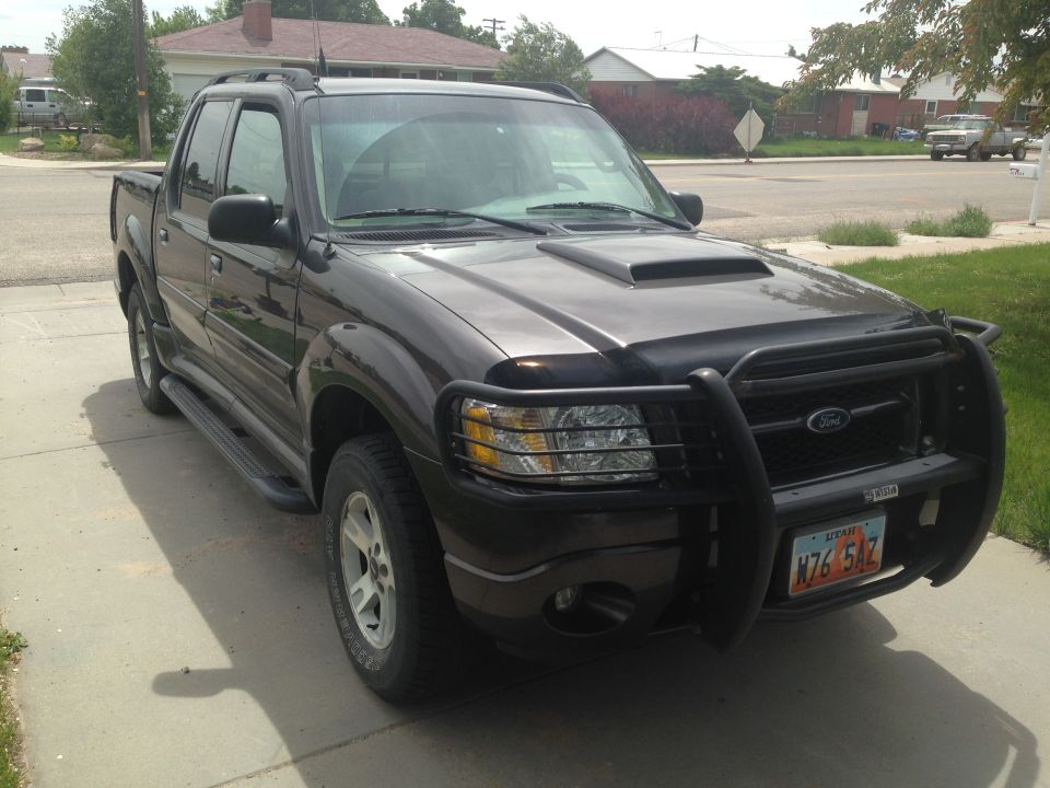 Dark gray Ford Sport Trac with a bull bar and hood scoop. License plate reads N76 5AZ