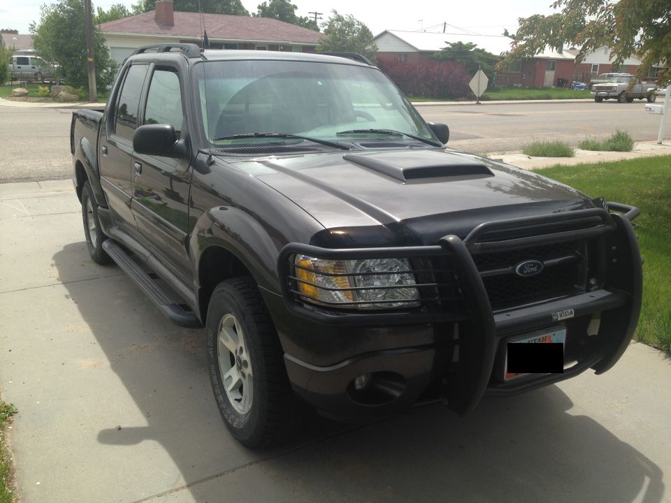 Dark gray Ford Sport Trac with a black bull bar and hood scoop parked on a driveway