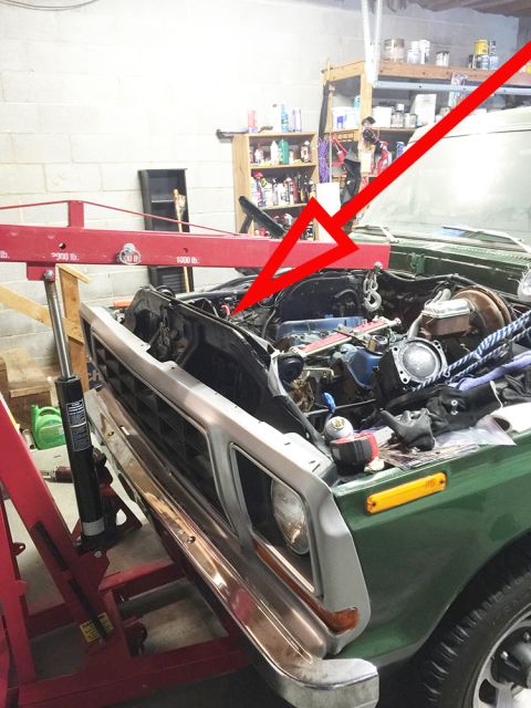 1978 Ford Bronco - Engine bay of a green 1978 Ford Bronco, with a red arrow indicating a specific area of the engine.
