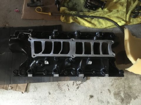 1987 Ford Bronco - Engine intake manifold part shown on a workbench, likely during a rebuild or repair.