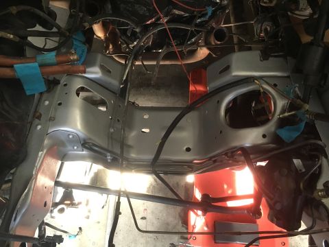 1987 Ford Bronco - The underside of a vehicle shows its frame and various engine components, possibly during a rebuild.