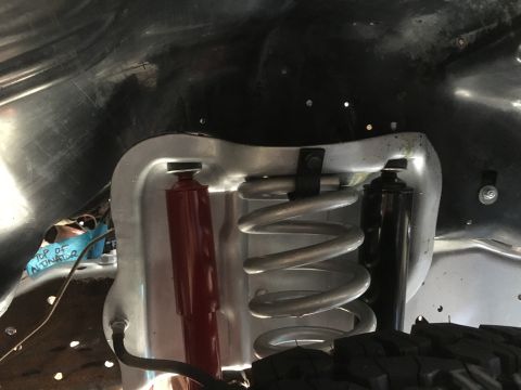 1987 Ford Bronco - Close-up of suspension components in a vehicle's engine bay, with handwritten notes on tape indicating 'TOP OF ALTERNATOR'.