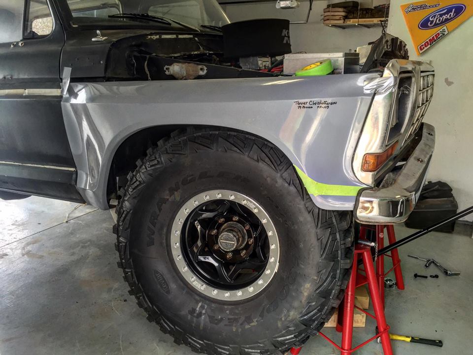 1979 Ford Bronco front fender and large off-road tire, supported by jack stands