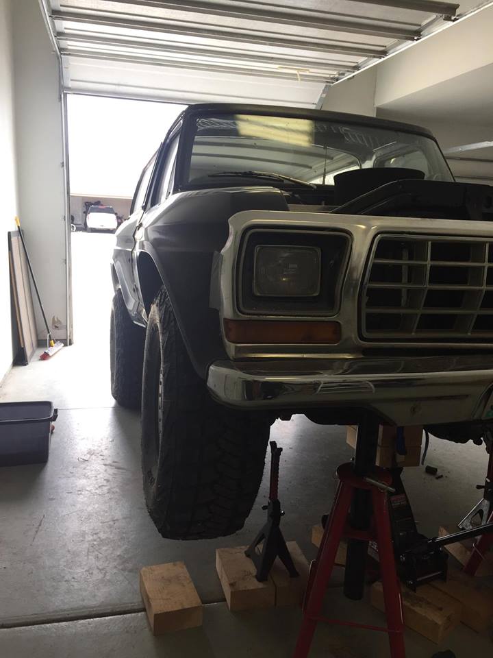 Black 1978 Ford Bronco on jack stands, hood up, in a garage