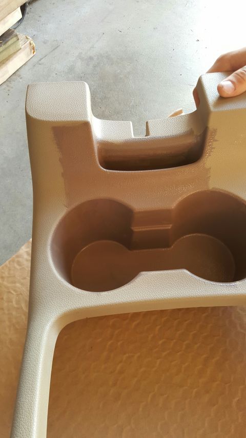 1996 Ford Bronco - Tan plastic center console with dual cup holders and a slot is shown.