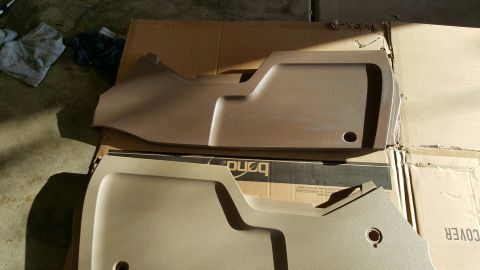 1996 Ford Bronco - Two tan interior trim pieces are shown resting on cardboard boxes.