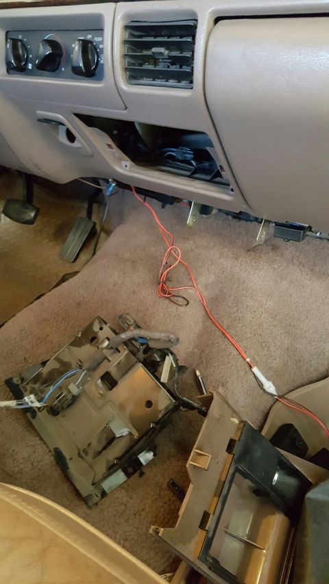 1996 Ford Bronco - The center console and surrounding dashboard components have been removed, exposing wiring and internal mechanisms.