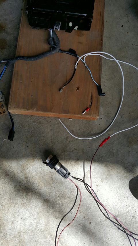 1996 Ford Bronco - A wiring harness and connector are laid out on a wooden board, with additional wires and clips visible.