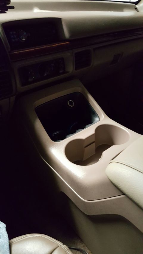 1996 Ford Bronco - Interior view of a 1996 Ford Bronco's center console, cup holders and a storage bin.