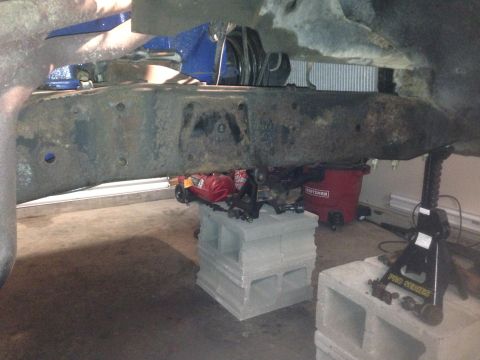 1979 Ford Bronco - The vehicle's frame and suspension are supported by cinder blocks and jack stands for maintenance.