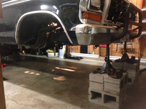 1979 Ford Bronco - Front end of a 1979 Ford Bronco is elevated on jack stands for suspension work.