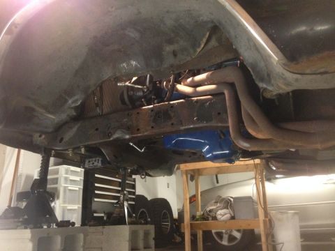 1979 Ford Bronco - The underside of a vehicle is shown, with visible suspension components and exhaust system.