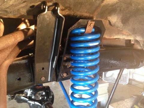 1979 Ford Bronco - Close-up view of a blue coil spring suspension system, showing the spring and surrounding frame components.