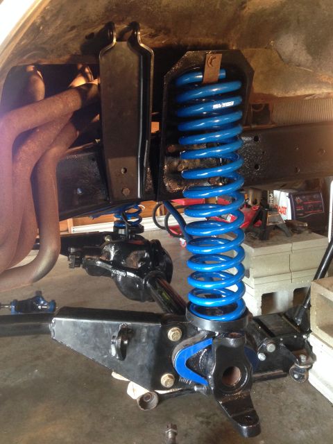 1979 Ford Bronco - Close-up of a vehicle's front suspension system, a bright blue coil spring.