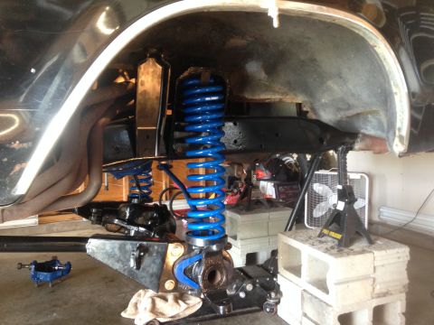 1979 Ford Bronco - The vehicle's suspension is being worked on, with new blue springs visible.