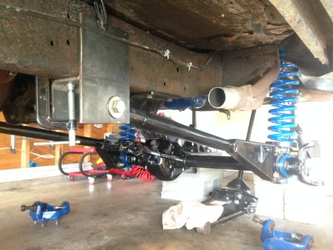 1979 Ford Bronco - Close-up view of a vehicle's undercarriage, highlighting newly installed blue suspension parts and a black differential.